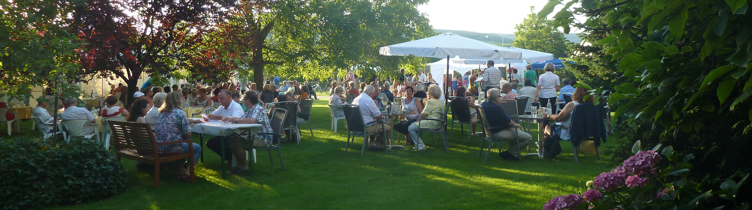 Besucher bei einem Weinfest im Garten des Weinguts Knöll & Vogel